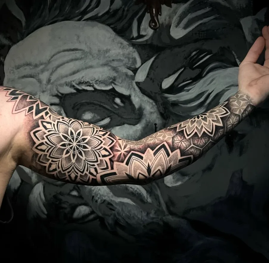 Brazo completo con mandalas y geometría en dotwork, tatuado en Mamba Tattoo